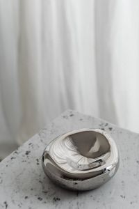 Kaboompics - Sculptural Chrome Bowl on Speckled Gray Stone Table, Minimal Neutral Metallic Still Life