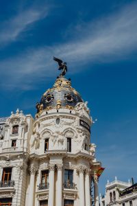 Kaboompics - Close-Up of the Metrópolis Sign and Winged Statue on Madrid’s Ornate Dome