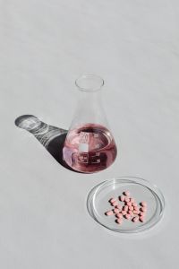 Kaboompics - Pink Chemistry Flask With Tablets and Copy Space