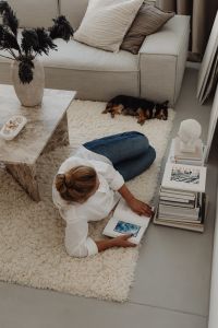 Kaboompics - Overhead View of Woman Reading on a Rug Beside a Sofa and Dog