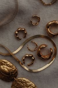 Kaboompics - Gold Hoops and Chain Jewelry on Textured Fabric