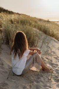 Kaboompics - Solitary Woman Sitting in Coastal Dunes at Golden Hour