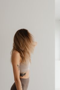 Kaboompics - Side View of Woman Standing Against a Light Wall