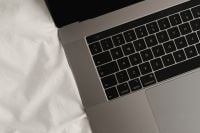 Kaboompics - Cropped Laptop Keyboard Detail on Soft White Sheets