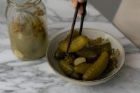 Kaboompics - Hand Picking a Pickle from a Bowl with Chopsticks, Dill and Garlic