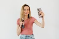 Kaboompics - Woman Taking a Smartphone Selfie with a Cola Bottle, Casual Lifestyle and Social Media Content