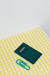 Kaboompics - Green Calculator and Paper Clip With Generous Copy Space