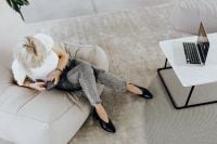 Kaboompics - Overhead View of Woman Relaxing on Sofa with Smartphone and Laptop