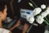 Kaboompics - Woman Working From Home Beside White Flower Bouquet