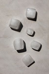 Kaboompics - Scattered Ice Cubes on White Textured Surface, Hard Sunlit Shadows and Minimal Summer Background