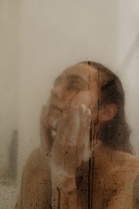 Kaboompics - Woman Washing Her Face Behind a Steamy Shower Door