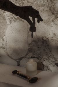 Kaboompics - Hand Holding a Skincare Dropper Above a Frosted Beauty Bottle