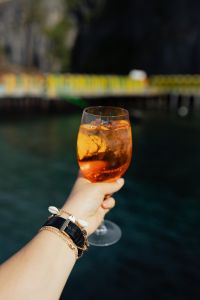 Kaboompics - Handheld Aperol Spritz over Dark Water with Copy Space