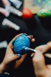 Kaboompics - Woman Painting Blue Easter Eggs