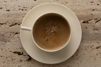 Kaboompics - Cream Coffee Cup From Above on Textured Stone Surface