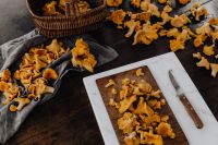 Kaboompics - Chanterelle Mushrooms On Wooden Board With Basket