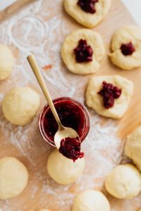 Kaboompics - Cherry Jam Spoon with Filled Paczki Dough in the Background