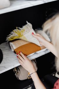 Kaboompics - Woman putting clothes on shelf