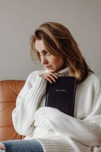 Kaboompics - Thoughtful Woman Holding a Holy Bible at Home