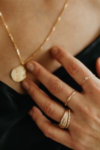 Kaboompics - Woman Touching Gold Pendant with Layered Rings