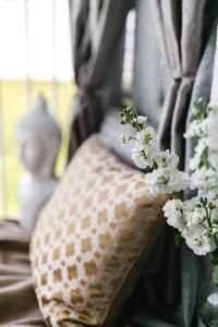 Kaboompics - White Blossoms and a Patterned Cushion with Buddha Statue in Soft Focus