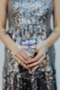 Kaboompics - Close-Up Champagne Coupe Held over a Silver Sequin Dress