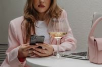 Kaboompics - Woman in Pale Pink Suit with Smartphone and Wine Glass
