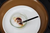 Kaboompics - Overhead Yogurt Jar on a White Plate over a Brown Tray