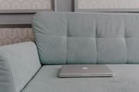Kaboompics - MacBook laptop lying on mint couch