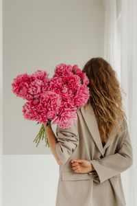 Kaboompics - Woman in Beige Suit Holding a Large Pink Peony Bouquet