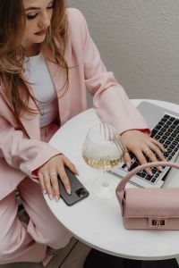 Kaboompics - Woman Using a Laptop and Smartphone Beside a Wine Glass