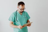 Kaboompics - Doctor Reading Clipboard Against Light Background
