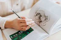 Kaboompics - Close-Up of Woman Drawing in Open Book