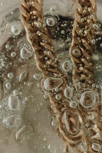 Kaboompics - Gold Chain Detail on Textured Surface with Water Droplets