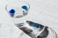 Kaboompics - Water Glass and Long Blue-Tinted Shadow on Linen, Wide Minimal Background with Copy Space