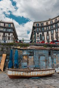 Kaboompics - Weathered Fishing Boat Below Curved Naples Waterfront Buildings