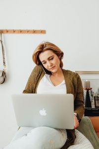 Kaboompics - Woman on a Phone Call Behind Laptop in Home Office with Copy Space