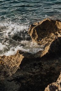 Kaboompics - Wave Breaking Against a Golden Rock Ledge