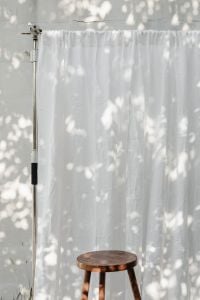 Kaboompics - Cloud Dancer White Curtain and Wooden Stool in Sunlight