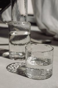 Kaboompics - Drinking Glass and Carafe Framed by Sheer Curtains