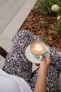 Kaboompics - Woman Holding a Cappuccino in a Cafe Chair