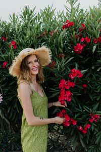 Kaboompics - Summer Portrait of a Woman Holding a Pink Flower Branch Outdoors