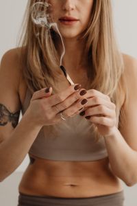 Kaboompics - Close-Up of Woman Holding a Smoking Palo Santo Stick With Both Hands
