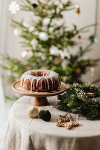 Kaboompics - Iced Bundt Cake with Christmas Greenery and Soft Focus Tree
