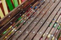 Kaboompics - Diagonal Close-Up of Worn Wooden Bench Slats with Multicolor Metal Supports at Manufaktura