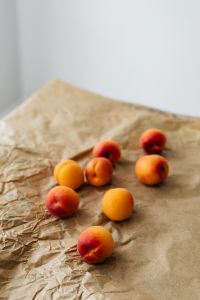 Kaboompics - Small Group of Fresh Apricots on Brown Paper, Farm-Fresh Fruit Still Life for Menu Design