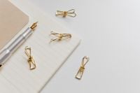 Kaboompics - Silver Fountain Pen and Gold Paper Clips on Lined Notebook with Generous White Desk Copy Space