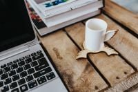 Kaboompics - Silver laptop and a white mug on a wooden box table