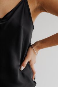 Kaboompics - Ringed Hand Touching Black Satin Camisole