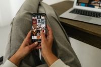 Kaboompics - Holding Smartphone With Social Media Feed Home Office